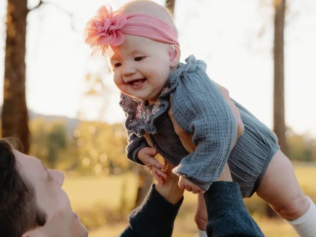 Lydia smiling as she is lifted into the air