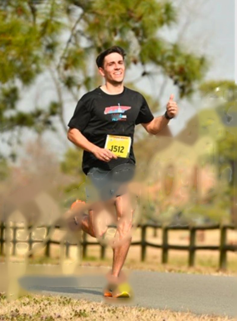 Leo running in a race with a bib, giving a thumbs up